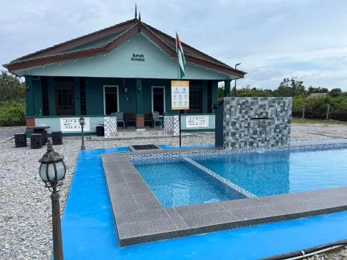 a resort with a swimming pool in front of a building at Rumah Armand Private Pool 5 bilik Pengkalan Balak Tg Bidara Masjid Tanah Melaka in Masjid Tanah