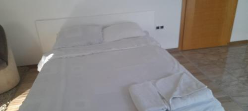 1 Schlafzimmer mit 2 Betten und weißer Bettwäsche in der Unterkunft Hana apartman 04 in Sarajevo