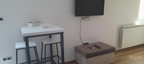 Zimmer mit einem Tisch, einem Stuhl und einem TV in der Unterkunft Hana apartman 04 in Sarajevo