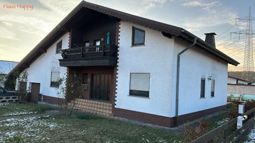 ein weißes Haus mit einem Balkon an der Seite in der Unterkunft Apartment Happy in Homburg