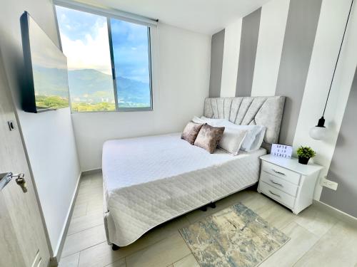 a small bedroom with a bed and two windows at Habitación premium sede 3 in Ibagué