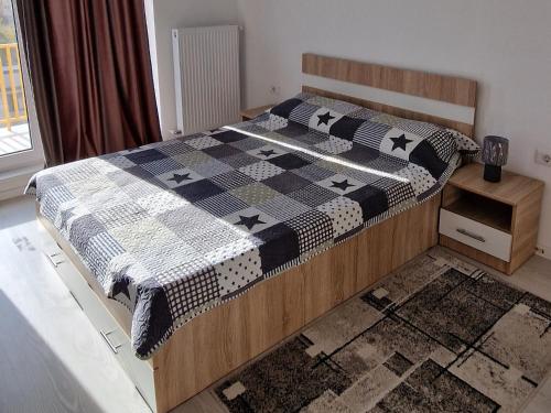 een slaapkamer met een bed met een zwart-witte quilt bij Titan 4 Residance in Boekarest