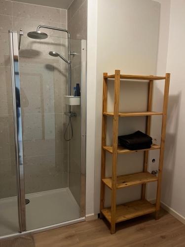 uma casa de banho com um chuveiro e uma prateleira de madeira. em Budget Flex em Geel