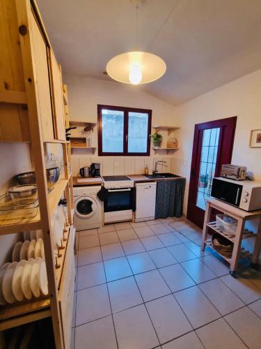 Il comprend une cuisine dotée de carrelage et d'une cuisinière. four supérieur dans l'établissement Maison familiale a 15 mns du centre ville, à Nantes