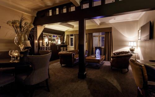 a living room with a couch and a table and chairs at The Vermont ApartHotel in Newcastle upon Tyne
