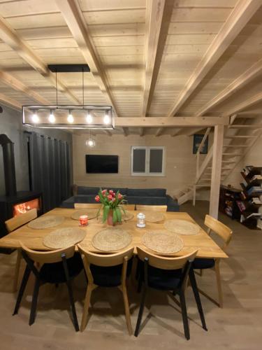 ein Esszimmer mit einem Holztisch und Stühlen in der Unterkunft Mielno Woodhouse in Mielno