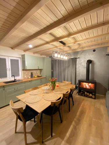 a kitchen with a table and chairs and a fireplace at Mielno Woodhouse in Mielno