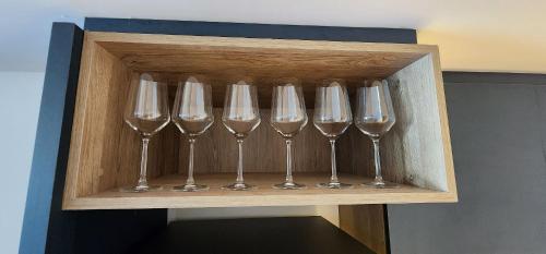 una fila di bicchieri da vino in una scatola di legno di Luxury and Modern Aptartment en Distrito Quartier a Buenos Aires