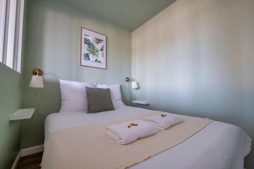 ランスにあるLe Clovis - Cathédraleの大きなベッドとタオル2枚のある寝室