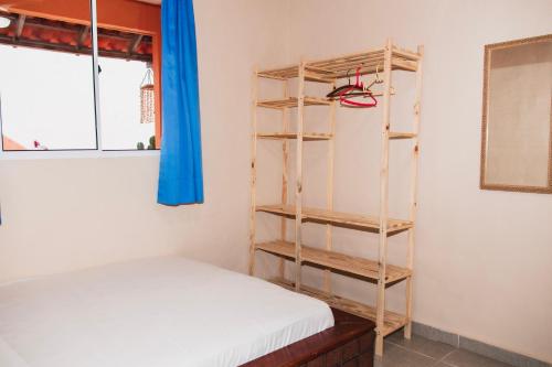 a bedroom with a bed and a book shelf at Casa Sol de Búzios in Búzios