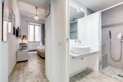 y baño blanco con lavabo y ducha. en Trevi Art Suite, en Roma