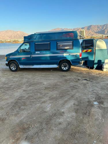 un camion bleu avec campeur et tente dans l'établissement הקראוון של תומר, à Eilat