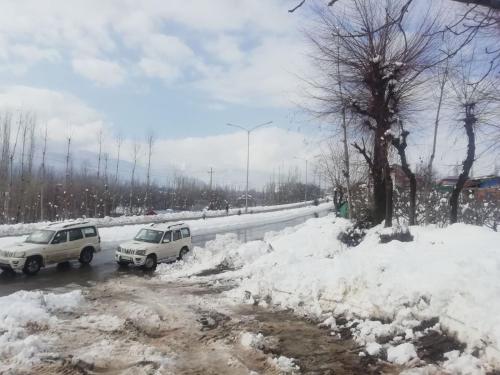 two cars parked on a road covered in snow at THE GULMARG PALACE in Gulmarg