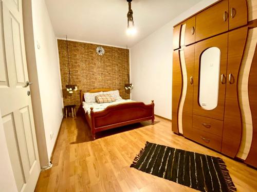a bedroom with a bed and a brick wall at Twins Apartments 2 in Ploieşti