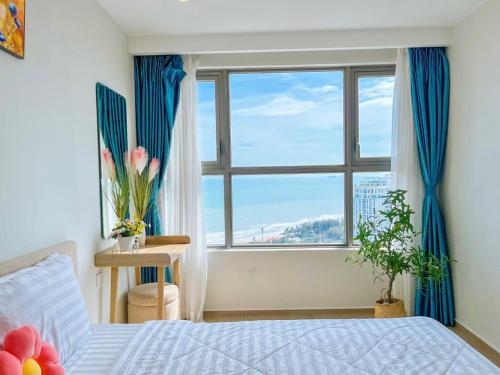 a bedroom with a bed and a large window at The Song Balcony Apartment Vung Tau in Vung Tau