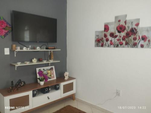 a living room with a flat screen tv on a shelf at Casa praia para temporada Parque Mambucaba Angra in Angra dos Reis