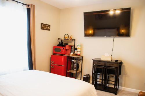 a bedroom with a bed and a tv on the wall at HomeTel Premium Guest Suite w/ Private Entrance in Ypsilanti