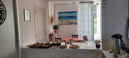 a table with food on it in a room with a window at Chambres et Gîtes Les Deux Chênes près de Bergerac in Le Fleix