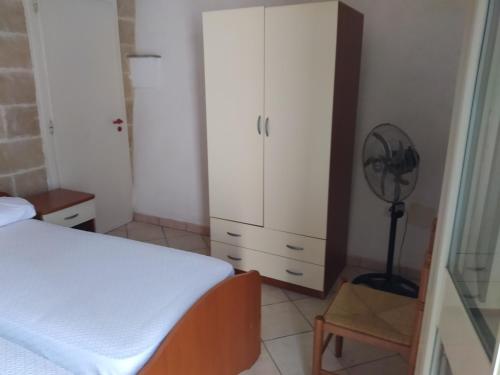 モルチャーノ・ディ・レウカにあるCasa Antonioのベッドルーム1室(ベッド1台、白いキャビネット、ファン付)