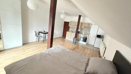 1 dormitorio con 1 cama y cocina con mesa en Penzion u přehrady, en Štěchovice