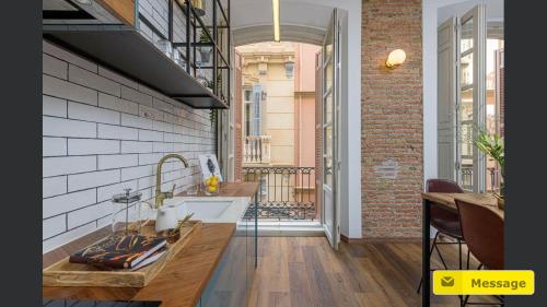 a kitchen with a sink and a balcony at Glamorous Niño de Guevara on The City Center in Málaga