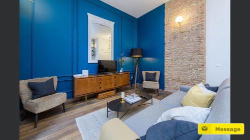 a blue living room with a couch and a tv at Glamorous Niño de Guevara on The City Center in Málaga