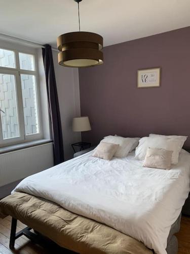 une chambre avec un grand lit blanc avec une fenêtre dans l'établissement Maison entière proche tram 170 m2 jardin parking, à Marcq-en-Barœul