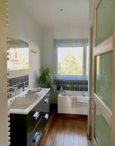 La salle de bains est pourvue d'une baignoire, d'un lavabo et d'une chambre. dans l'établissement Maison entière proche tram 170 m2 jardin parking, à Marcq-en-Barœul