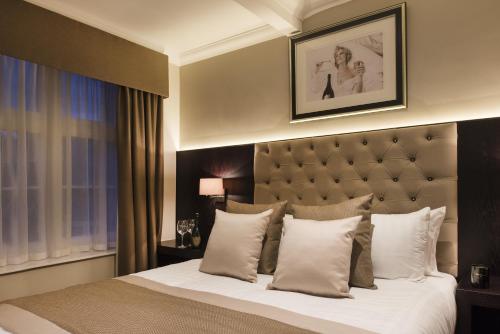 ein Schlafzimmer mit einem großen Bett und weißen Kissen in der Unterkunft The Vermont ApartHotel New in Newcastle upon Tyne