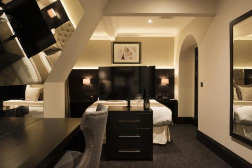 a hotel room with a large bed and a large mirror at The Vermont ApartHotel in Newcastle upon Tyne