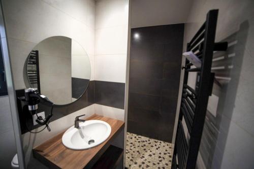 La salle de bains est pourvue d'un lavabo et d'un miroir. dans l'établissement Chambres d'hôtes les Hirondelles, à Lanne-en-Barétous 