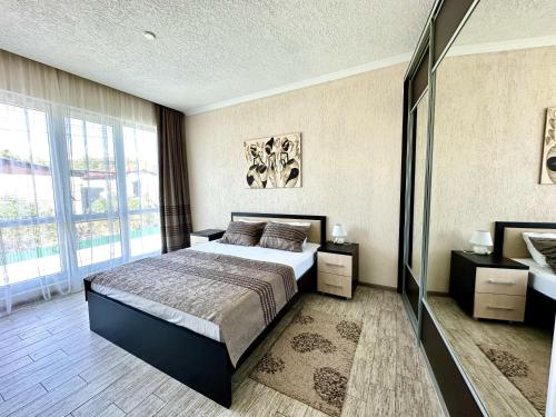 1 dormitorio con cama y ventana grande en Hotel Solntse Abkhazii, en Pitsunda