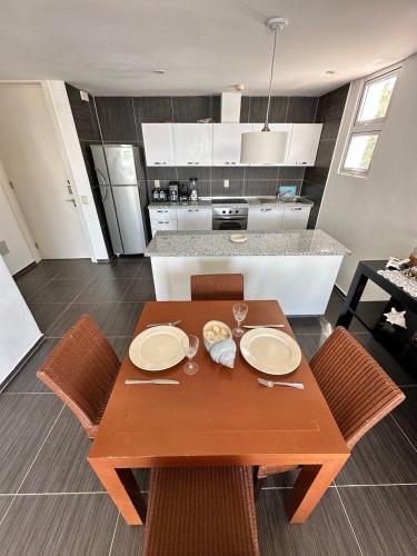 a wooden table with plates on it in a kitchen at Vista Mare Spectacular Ocean View Top Floor 1-Bedroom Condo, Samana in Santa Bárbara de Samaná