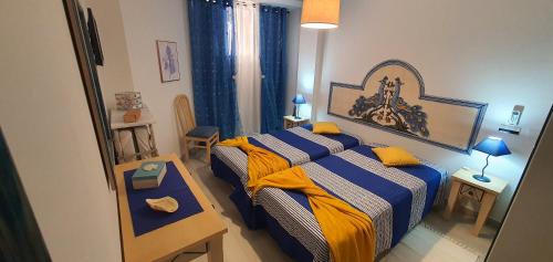una camera con letto con lenzuola blu e gialle di Monte Gordo T1 Parque dos Reis a Monte Gordo
