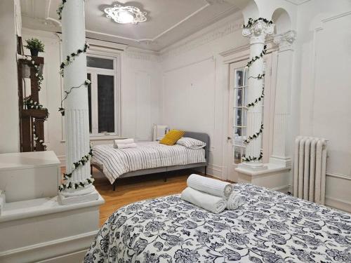 a white room with two beds in it at Mona Bella Beautiful Home In Mile End in Montreal