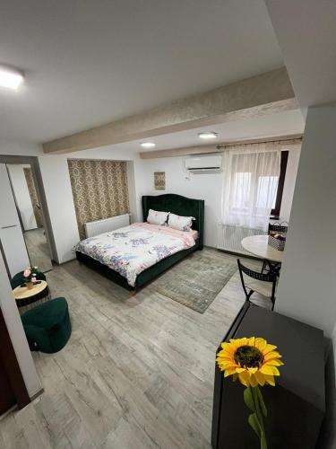 - une chambre avec un lit et une table avec un tournesol dans l'établissement Solaria Studio, à Galaţi