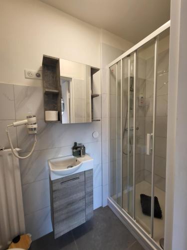 une salle de bain blanche avec un lavabo et une douche dans l'établissement Happy Studio 47 B St Louis, à Saint-Louis