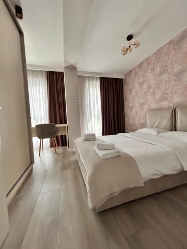 a hotel room with a large bed and a chair at Elegance in Bucharest