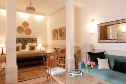 een woonkamer met een bank en een tafel bij La Villa des Orangers - Relais & Châteaux in Marrakesh