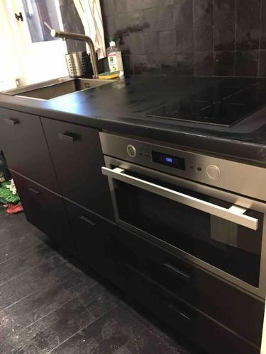 une cuisine avec une cuisinière et un évier dans l'établissement Le silence des toits / Silence under the roofs, à Lyon