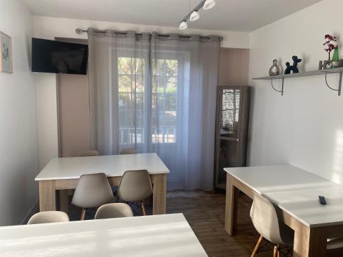 a dining room with a table and chairs and a window at Chambres et Gîtes Les Deux Chênes près de Bergerac in Le Fleix