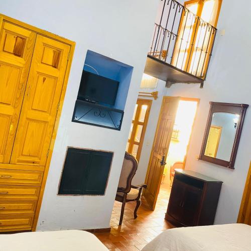 a room with a bedroom with a bed and a tv at Hotel Antigua Casa de Piedra in San Miguel de Allende