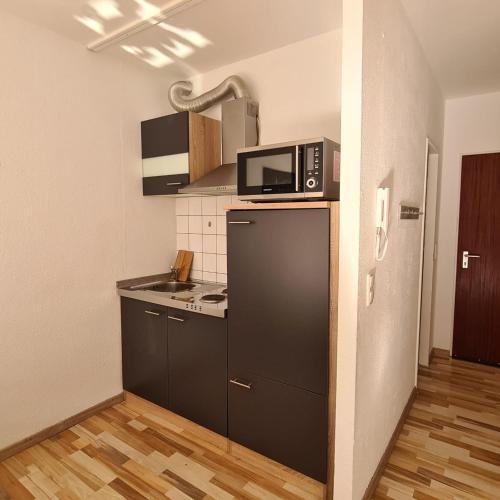 a kitchen with a microwave on top of a refrigerator at Zentrales Apartment mit Balkon und Parkplatz in Trier