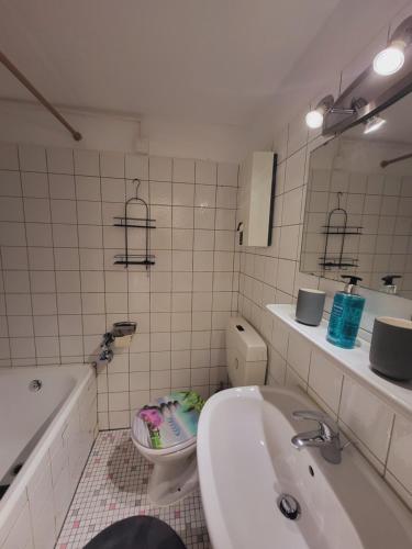 a bathroom with a sink and a toilet and a tub at Zentrales Apartment mit Balkon und Parkplatz in Trier