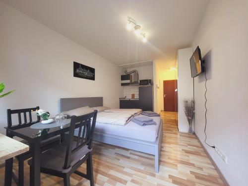 Zentrales Apartment mit Balkon und Parkplatz في ترير: غرفة نوم بسرير وطاولة طعام