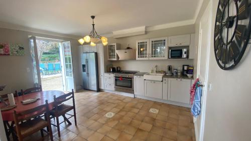 a kitchen with a table and a dining room at Chambres et Gîtes Les Deux Chênes près de Bergerac in Le Fleix
