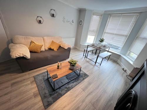 a living room with a couch and a table at Cosy apartment with parking close to Ipswich station in Ipswich