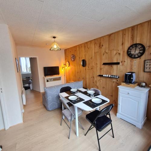 un salon avec une table et quelques chaises dans l'établissement Bel appartement « Les Monts du Cantal », à Murat