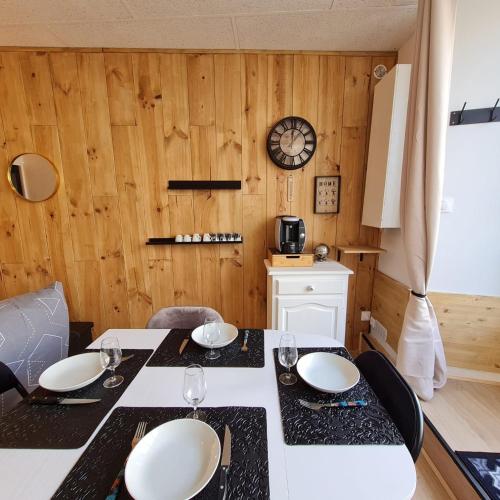 穆拉特的住宿－Bel appartement « Les Monts du Cantal »，一间带桌椅和时钟的用餐室
