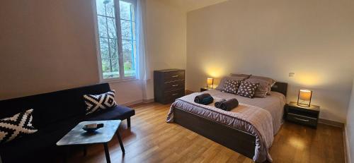 - une chambre avec un lit et un canapé dans l'établissement Chambre Les Deux Chênes près de Bergerac, à Le Fleix